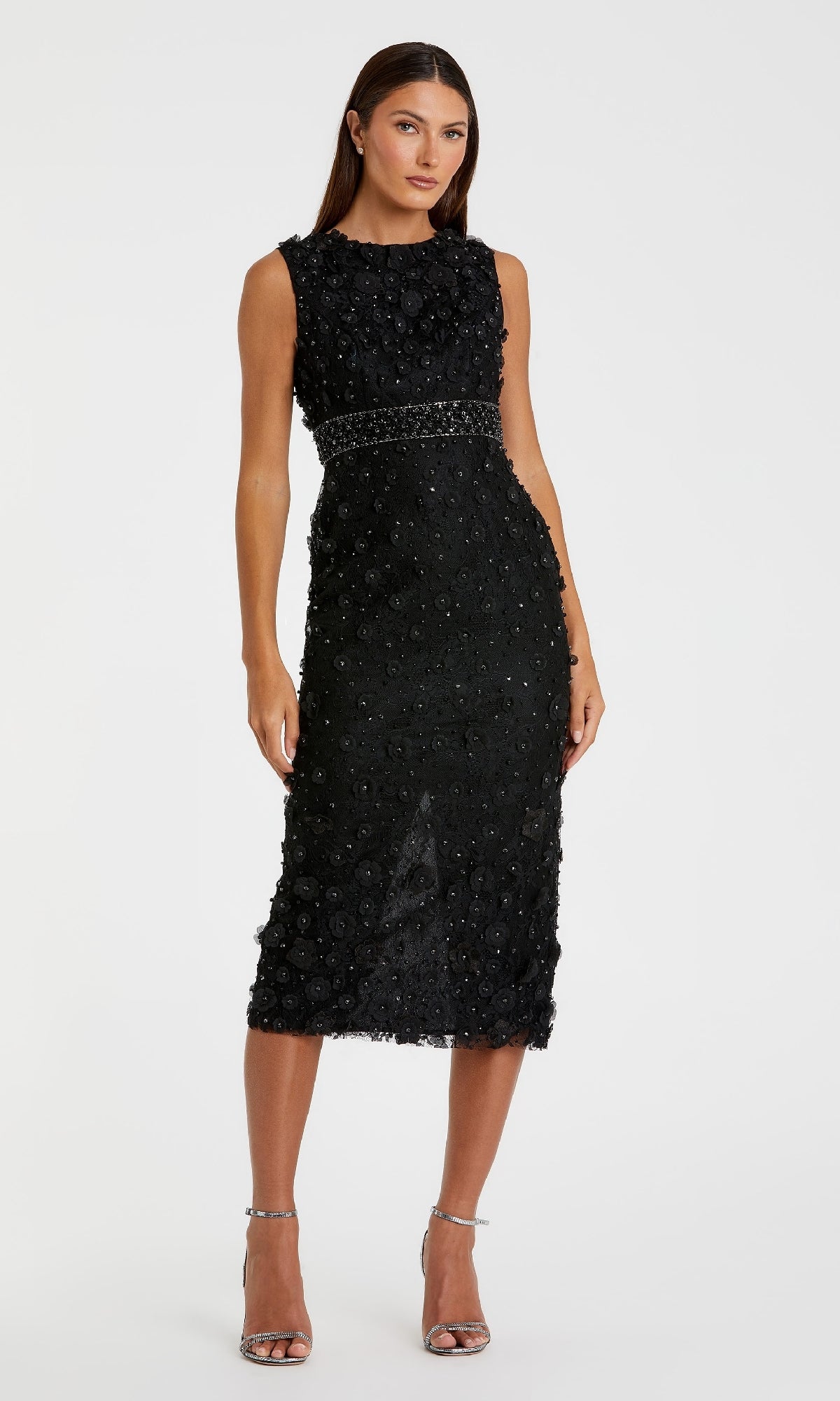 A woman stands facing forward, wearing the Mac Duggal 67853 Knee-Length Party Dress with textured embellishments and silver high-heeled sandals.